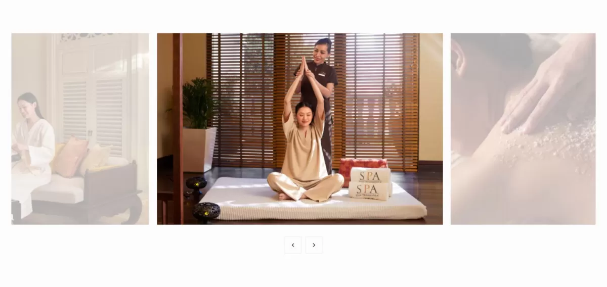 Wellness carousel: a therapist guides a guest through a seated stretch in a teak-shuttered room.