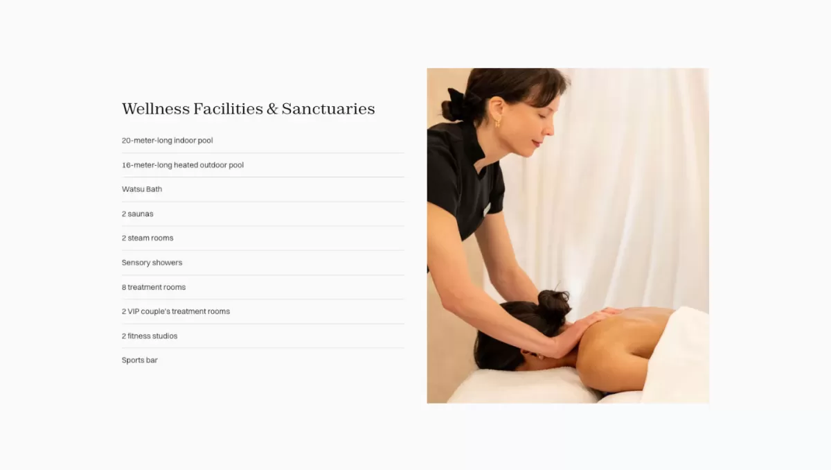 A spa therapist performing a targeted back and neck massage on a female guest lying down on a white treatment table against a soft backdrop.